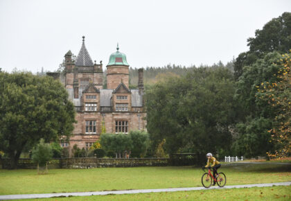 Person cycling in front of Holker Hall.