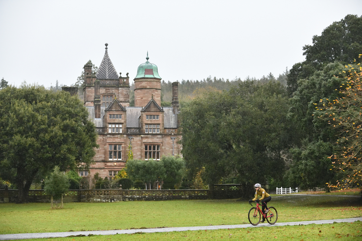Person cycling in front of Holker Hall.
