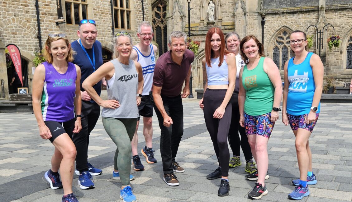 Nine people pose in running kit.